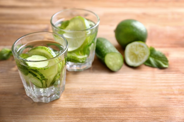 Délicieuse eau rafraîchissante à la menthe et au concombre dans des verres sur une table en bois