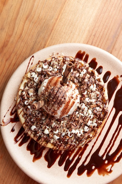 Délicieuse gaufre à la crème glacée au chocolat sur une table en bois