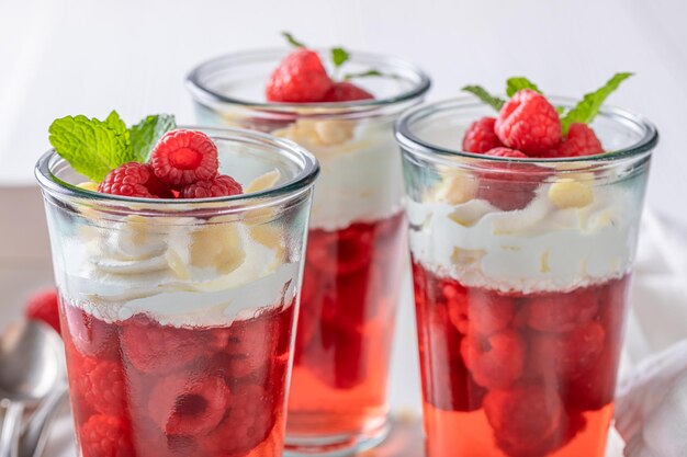 Délicieuse gelée rouge servie en verre avec des framboises