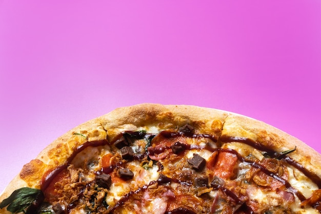 Délicieuse grande pizza au bacon et aux épinards sur fond rose