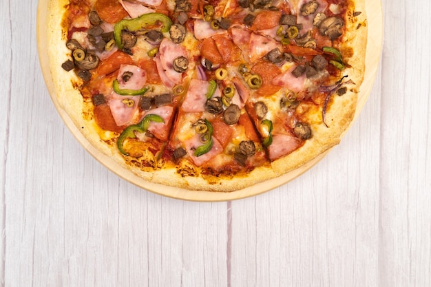 Délicieuse grande pizza au veau et aux champignons sur fond de bois clair