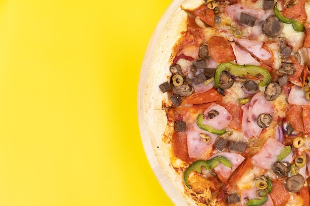Délicieuse grande pizza au veau et champignons sur fond jaune.