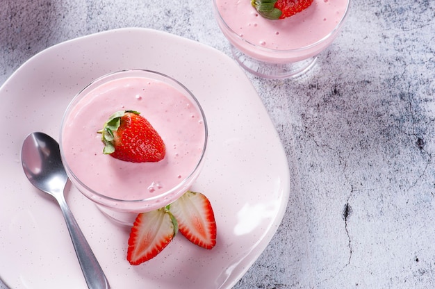 Délicieuse mousse aux fraises dans un bol en verre avec des fraises fraîches. Vue de dessus. Espace de copie