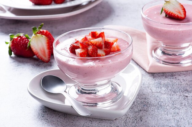 Délicieuse mousse aux fraises dans un bol en verre avec des fraises fraîches.