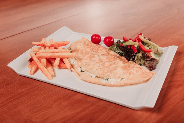 Délicieuse omelette et assiette de petit-déjeuner sur la table.