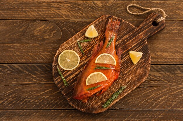 Délicieuse perche de poisson fumé sur une planche à découper en bois pour une alimentation saine, un régime ou un concept de cuisine, mise au point sélective.