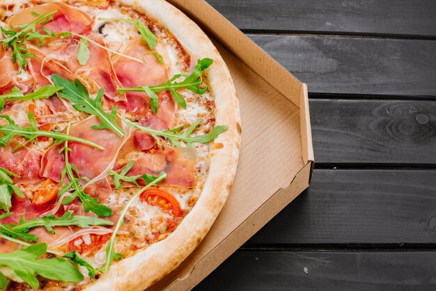 Délicieuse pizza au jambon et fromage sur fond de bois