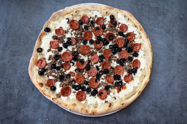 Délicieuse pizza au pepperoni avec béchamel et boeuf sur la vue de dessus de table rustique