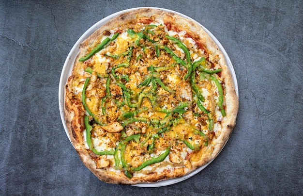 Photo délicieuse pizza au poulet avec cheddar et poivrons verts sur la vue de dessus de table rustique