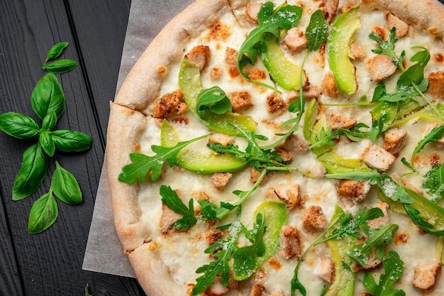 Délicieuse pizza au poulet grillé, avocat et roquette