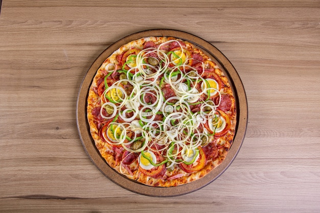 Délicieuse pizza avec beaucoup de garniture sur une table en bois