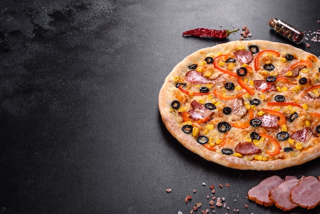 Délicieuse pizza fraîche faite dans un four à sole avec olives, piment et jambon