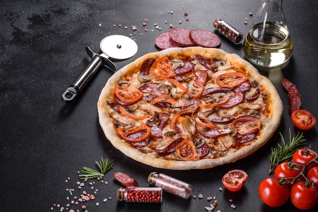 Délicieuse pizza fraîche faite dans un four à sole avec saucisses, poivrons et tomates. Cuisine méditerranéenne