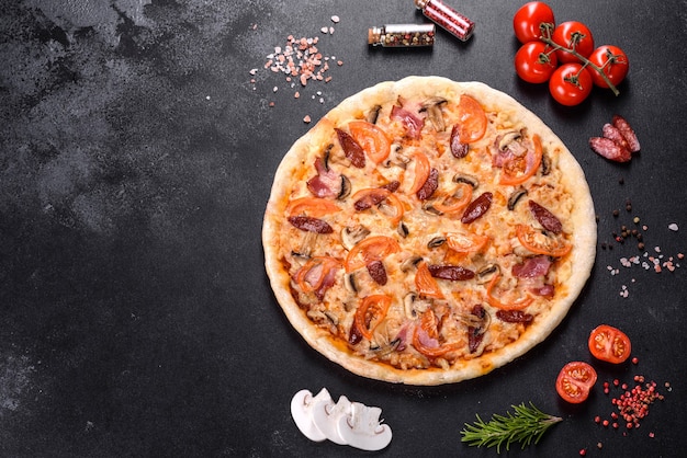 Délicieuse pizza fraîche faite dans un four à sole avec tomates, saucisses et champignons. Cuisine méditerranéenne