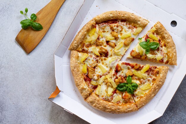 Délicieuse pizza hawaïenne dans une boîte en carton