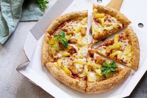 Délicieuse pizza hawaïenne dans une boîte en carton