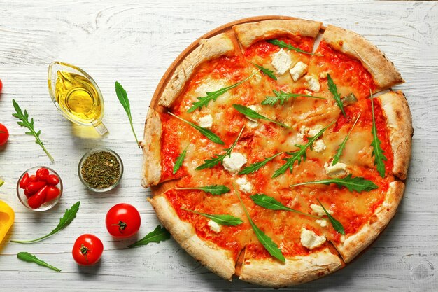 Délicieuse pizza avec des ingrédients sur une table en bois