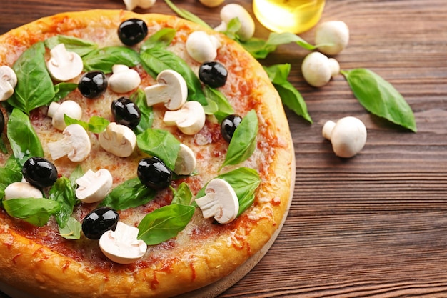 Délicieuse pizza savoureuse avec des ingrédients sur la table en bois