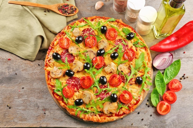 Photo délicieuse pizza savoureuse avec des ingrédients sur la table en bois