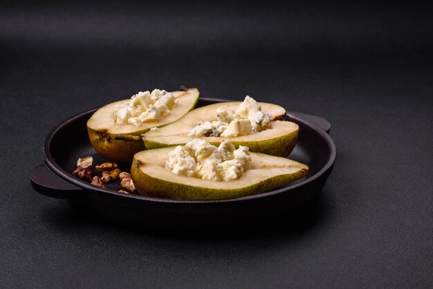 Délicieuse poire au four avec noix de fromage dorblu et miel sur fond de béton texturé