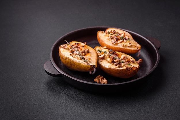 Délicieuse poire au four avec noix de fromage dorblu et miel sur fond de béton texturé