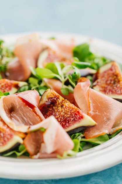 Délicieuse salade d&#39;automne appétissante avec jambon, balsamico et figues servis sur une assiette. Fermer