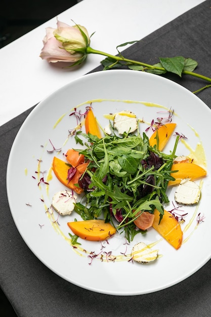 Délicieuse salade aux figues roquette et fromage de chèvre sur la vue de dessus de la plaque blanche