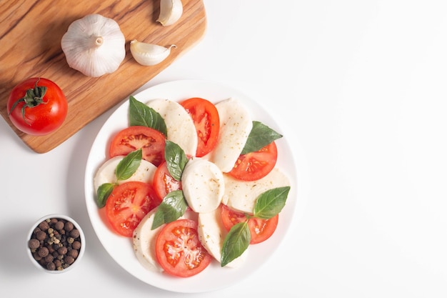 Délicieuse salade caprese italienne avec tomates mozzarella en tranches pesto basilic et ail sur fond