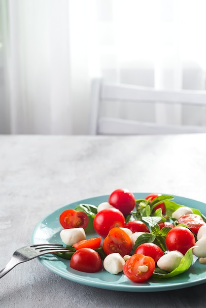 Délicieuse salade caprese avec tomates cerises mûres et mini boulettes de fromage mozzarella