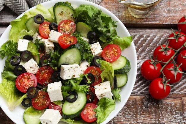 Une délicieuse salade avec du fromage feta sur une table en bois.