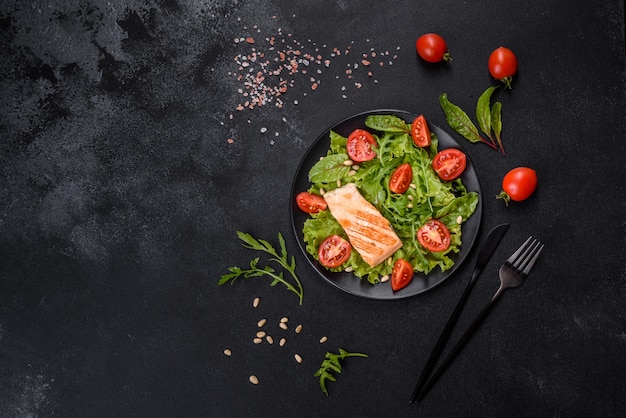 Délicieuse salade fraîche avec du poisson, des tomates et des feuilles de laitue. La nourriture saine