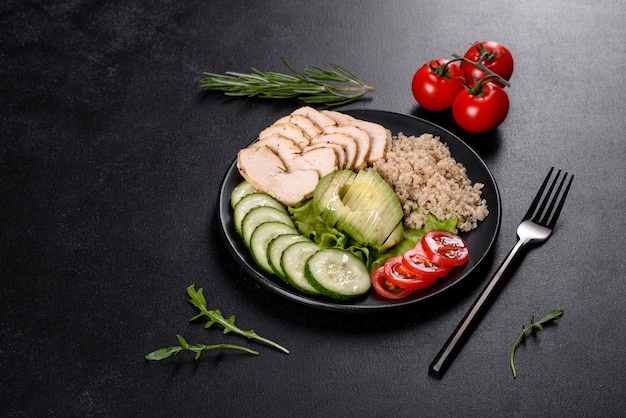 Délicieuse salade fraîche avec quinoa, poulet et légumes frais sur une assiette