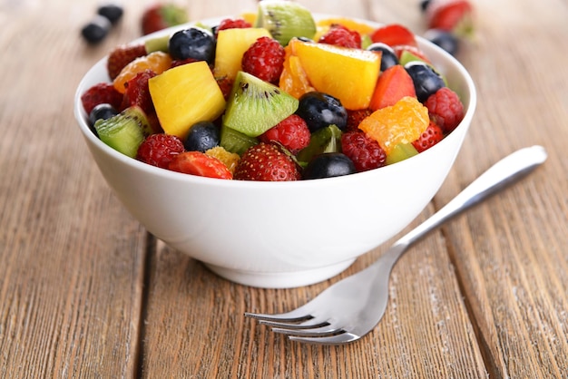 Délicieuse salade de fruits dans l'assiette sur le gros plan de table