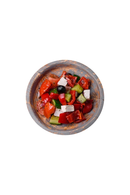 Délicieuse salade grecque juteuse fraîche avec du fromage feta olives poivrons tomates concombre et oignons sur un fond de béton gris