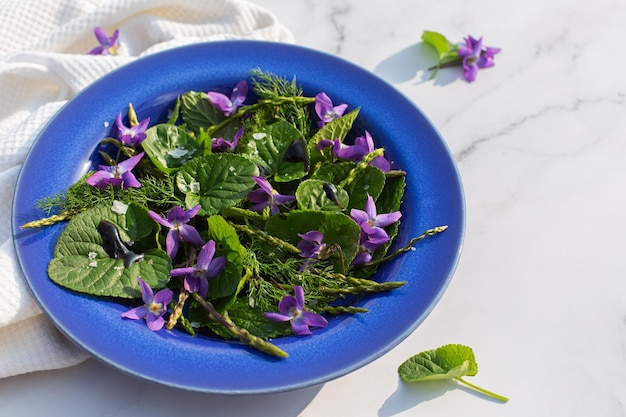 Délicieuse salade de laitue et de fleurs sauvages dans un bol