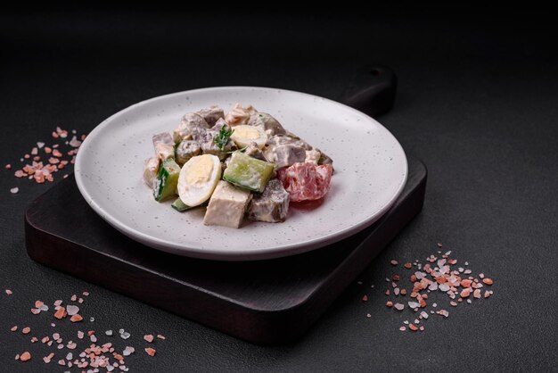 Délicieuse salade avec des œufs de caille à la langue de boeuf bouillie, des tomates et du concombre