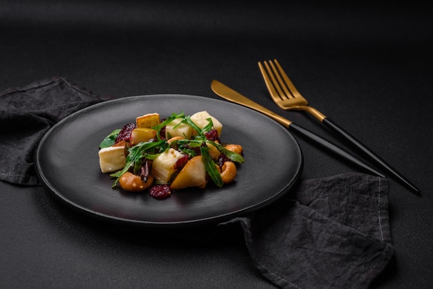 Délicieuse salade végétalienne fraîche avec des noix et des céréales au fromage brie aux poires et de la roquette