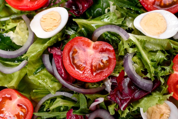 Délicieuse salade végétarienne fraîche de légumes hachés sur une assiette sur un fond de béton foncé