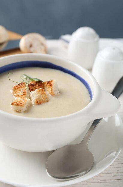 Délicieuse soupe à la crème avec des croûtons dans un bol sur le gros plan de table