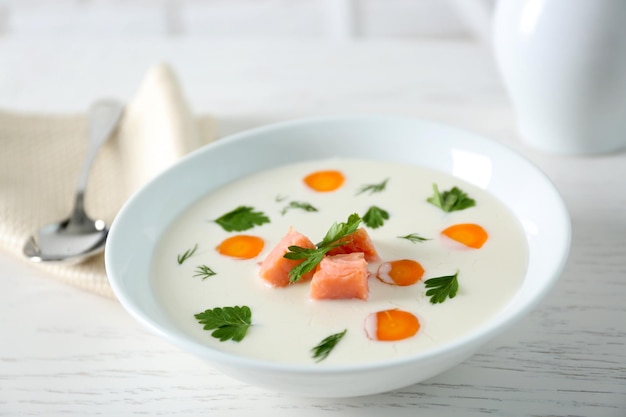 Délicieuse soupe à la crème de saumon et de carottes dans un bol blanc