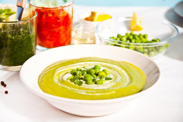 Délicieuse soupe de légumes avec pomme de terre, brocoli, pois verts et épinards sur la table du dîner.