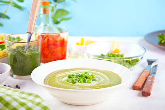 Délicieuse soupe de légumes avec pommes de terre, brocoli, pois verts et épinards sur la table du dîner