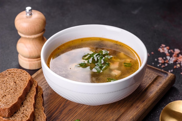 Délicieuse soupe saine avec pommes de terre à l'oseille, épices et herbes dans un bol blanc