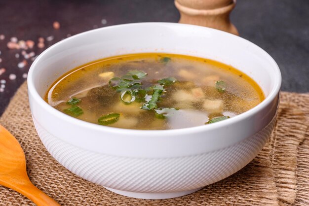 Délicieuse soupe saine avec pommes de terre à l'oseille, épices et herbes dans un bol blanc