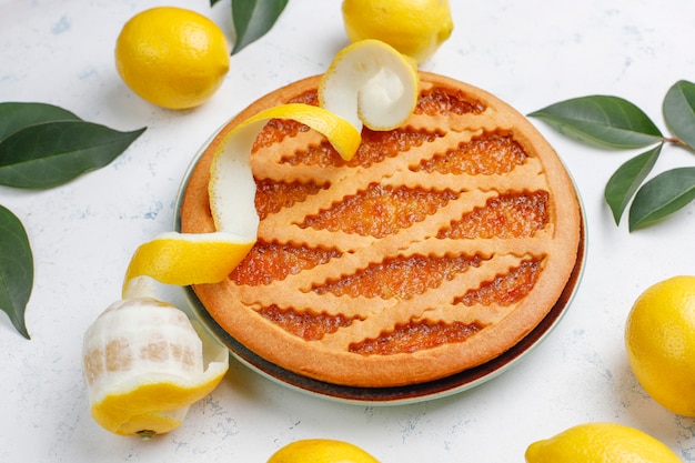 Délicieuse tarte au citron avec des citrons frais, vue de dessus