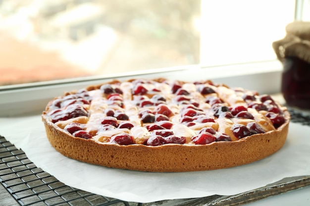 Photo une délicieuse tarte aux cerises sur le rebord de la fenêtre