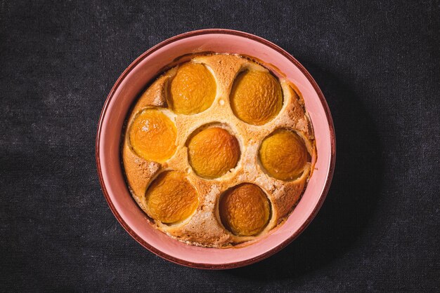 Délicieuse tarte aux pêches sucrée maison de forme ronde sur fond sombre