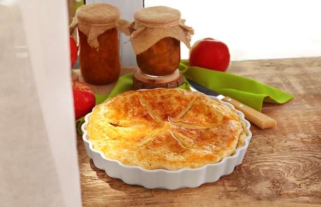 Délicieuse tarte et bocaux avec de la confiture sur le rebord de la fenêtre