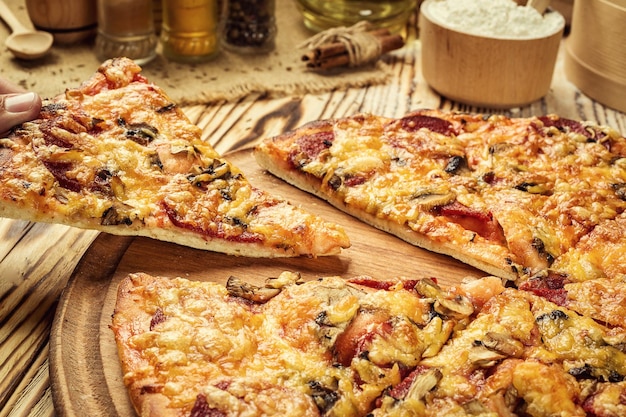 Délicieuse tranche de pizza maison chaude avec du fromage fondant sur une table en bois rustique prête à manger