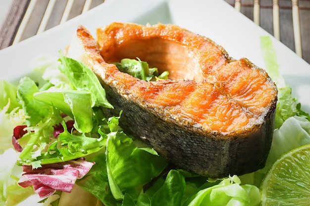 Délicieuse truite arc-en-ciel frite avec salade sur gros plan de plaque